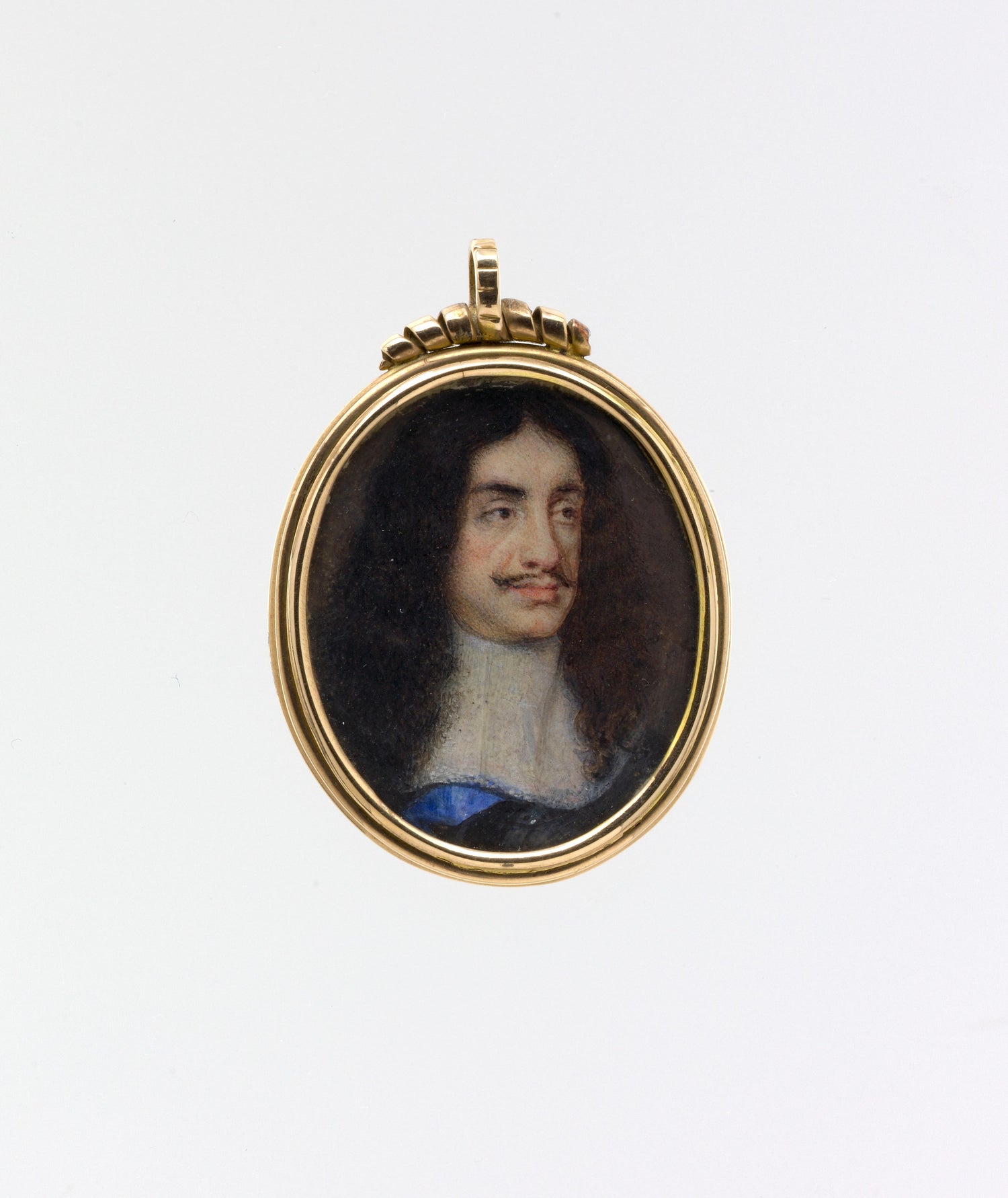 Portrait pendant of a man with dark hair and a white shirt, set in a gold frame on a white background.